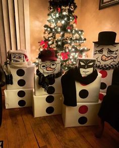 three cardboard boxes are decorated with black and white polka dots, one is wearing a top hat and the other has a christmas tree