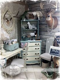 an old dresser with deer heads on the wall and other items in front of it