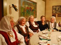 four women sitting at a table with plates and silverware