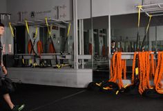 a man is walking past orange ropes in an industrial area with other items on the floor