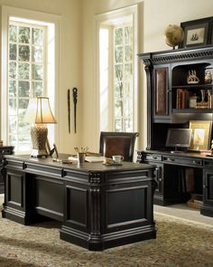 an office desk with two chairs and a bookcase