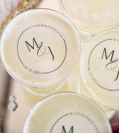 four personalized glasses with monogrammed labels on them