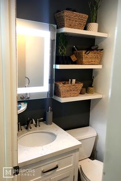 a white sink sitting under a bathroom mirror next to a shelf with baskets on it