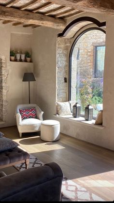 a living room filled with furniture next to a large window covered in windowsills