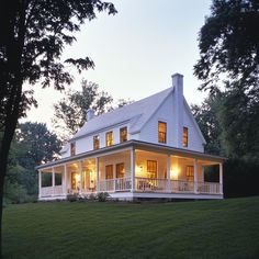 a large white house sitting on top of a lush green field