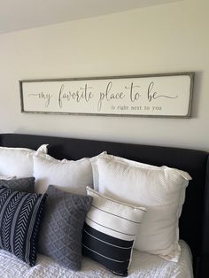 a bed topped with lots of pillows next to a sign that says my favorite place to be