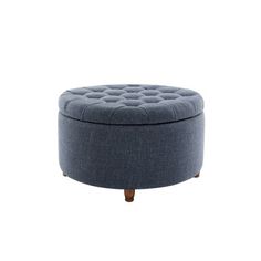 a round blue ottoman sitting on top of a white floor