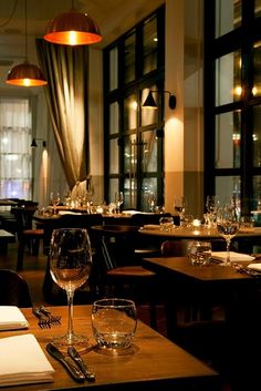 an empty restaurant with wine glasses and place settings