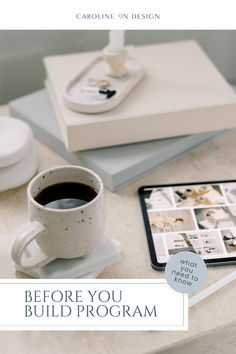 a coffee cup sitting on top of a table next to a book and tablet computer