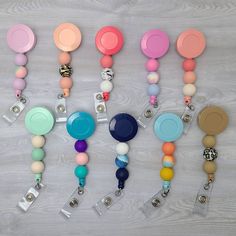 "These colorful decorative badge reels are just the thing you're looking for! They is made with a combination of silicone beads that have been permanently attached to this retractable badge reel.  A variety of colors to choose from in our shop! The badge reel itself from top to bottom is about 5.5\", these are all individually hand made so there may be a slight difference in length.  The badge reel has a retractable cord that is 34\" in length. This badge reel draws a lot of attention and compli Silicone Bead Badge Reel, Silicone Bead Ideas, Bead Badge Reel, Badge Reels Diy, Beaded Badge Reel, Car Hanging Accessories, Key Wristlet, Medical Tech, Beads Keychain