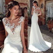 a woman in a white wedding dress standing next to a brick wall