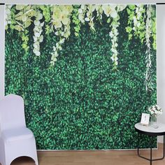 a white chair sitting in front of a wall covered with green leaves and flowers on it's side