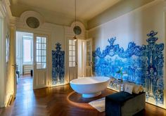 a bathtub in the middle of a room with blue and white wallpaper