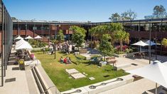 an aerial view of a courtyard with tables and umbrellas