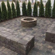 a brick fire pit surrounded by shrubbery