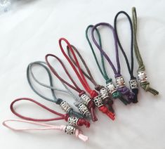 six different colored bracelets with charms on them