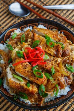 a bowl filled with rice and meat on top of a table