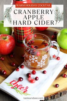 cranberry apple hard cider on a tray with apples