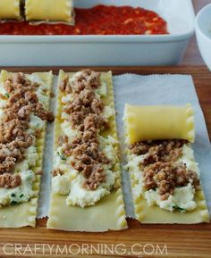 some ravioli with meat and cheese are on a wooden table next to bowls of condiments