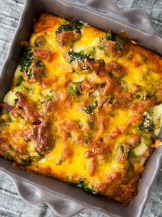 a casserole dish with broccoli, cheese and meat in it on a table