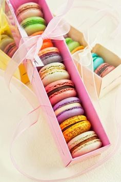 a pink box filled with lots of colorful macaroons