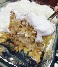 a piece of cake with white frosting on top is being held by a fork