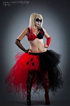 a woman in a red and black costume with her hands on her hips, posing for the camera