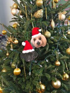 a christmas tree with ornaments and a dog ornament hanging from it's top