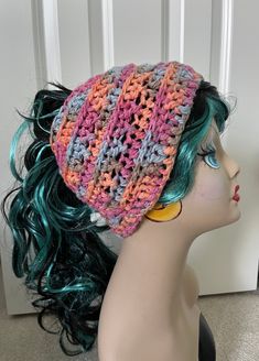 a mannequin head wearing a multicolored crochet hat