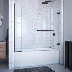 a bathroom with a white tile floor and black accents on the walls, along with a gray rug