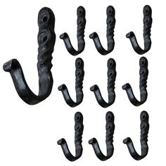 an assortment of black iron hooks on a white background