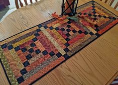 a quilted table runner on top of a wooden table