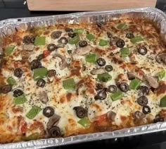 a pizza with mushrooms, peppers and cheese in a pan on top of a stove