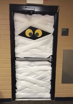 a door decorated with white paper and yellow eyes