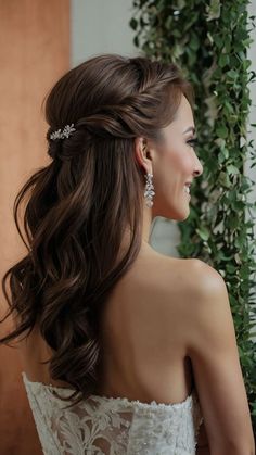 a woman in a wedding dress with long hair and earrings on her head, looking off to the side