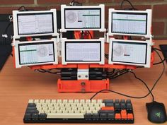 there are six computer monitors on top of the keyboard, which is connected to two keyboards