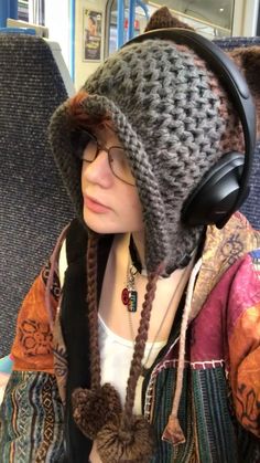 a woman wearing headphones while sitting on a train