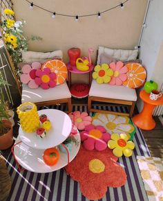 an outdoor seating area is decorated in bright colors and pops of pink, yellow, and orange