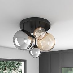 three lights are hanging from the ceiling in a kitchen with black cabinets and white walls