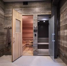 an open door leading to a sauna room with wood paneling and stone walls