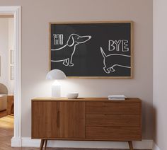 a dog is drawn on a chalkboard next to a wooden sideboard with a lamp