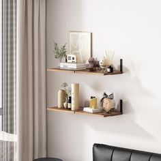 two wooden shelves on the wall above a couch in a room with white walls and curtains