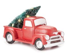 an old red truck with a christmas tree on the back is parked in front of a white background