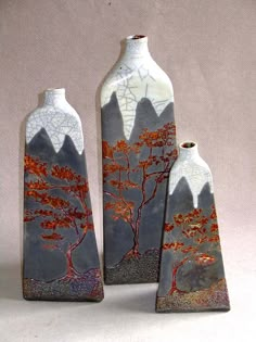 three vases with trees painted on them