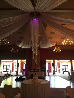 the ceiling is decorated with white draping and chandelier hanging from it