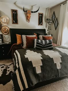 a bed room with a neatly made bed and animal heads on the wall above it