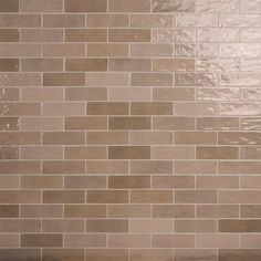 a white toilet sitting next to a tiled wall