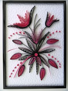 a white and black framed artwork with pink flowers on the bottom, and red petals on the top