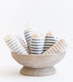 a basket filled with striped towels on top of a white table