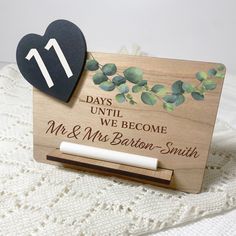 a wooden business card holder with a heart on it and the date 11 days until we become mr and mrs barton smith